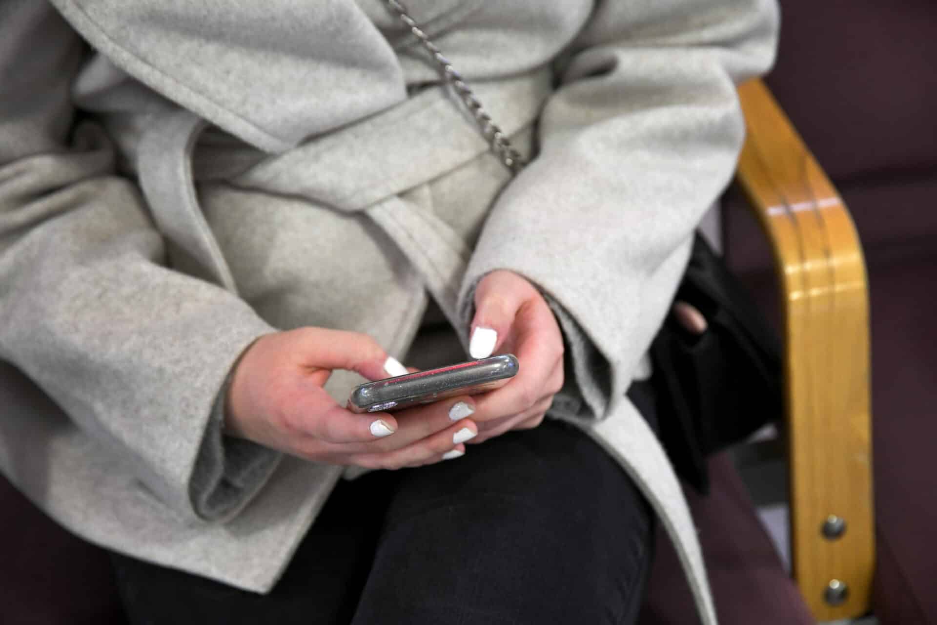 Henkilö kirjoittaa tekstiä puhelimella